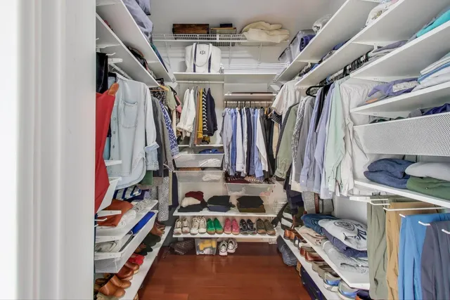 a view of walk in closet with clothes and shoes
