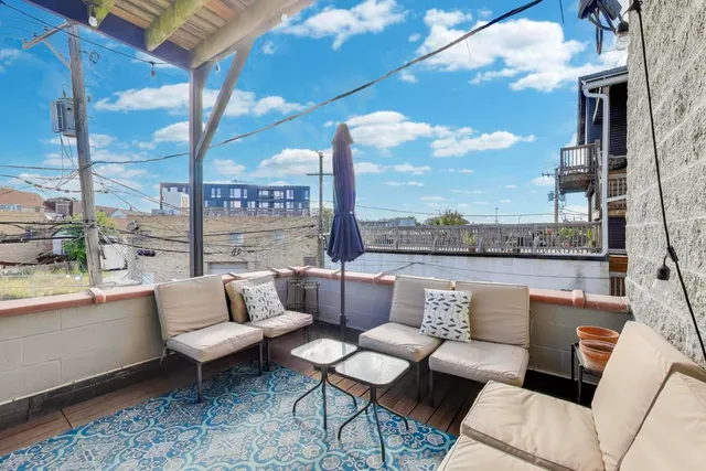 a roof deck with couches and potted plants