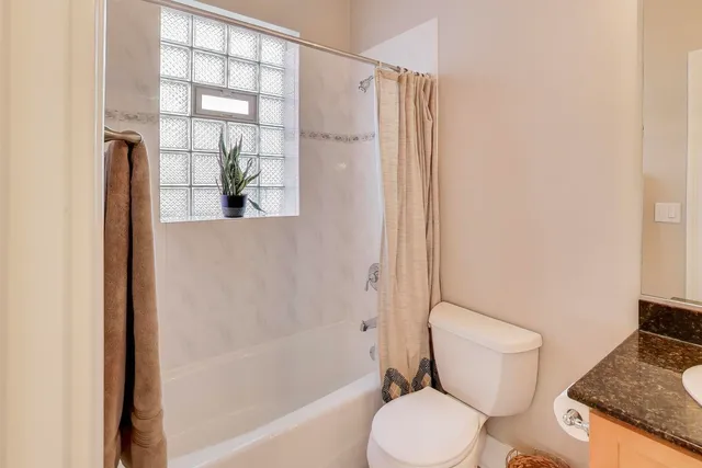 a white toilet sitting next to a bath tub