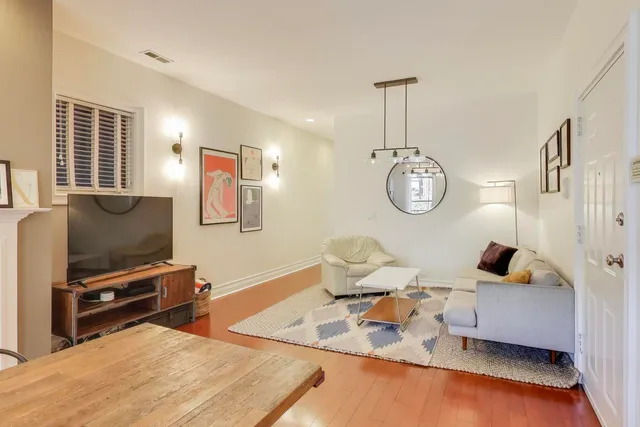 a living room with furniture a flat screen tv and a window
