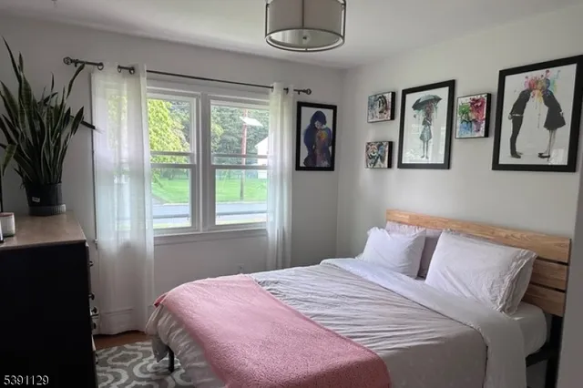 a bedroom with a bed and a large window