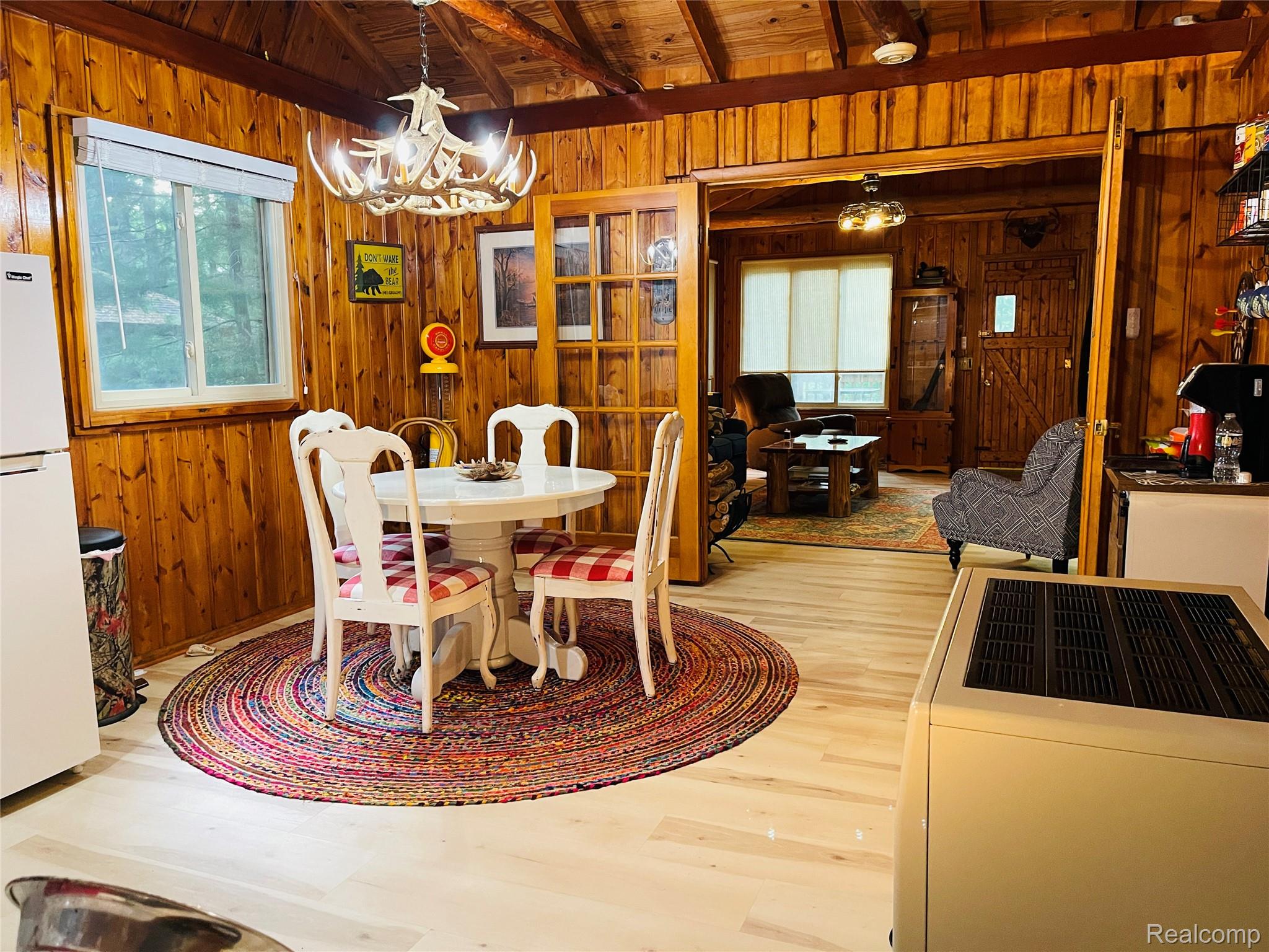 417 Ogemaw Road Rose City, MI 48654 - Photo 4 of 26 Light wood-finish flooring with wood paneling walls and ceiling