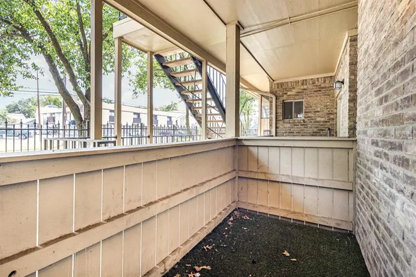 an empty room with a chandelier fan and windows