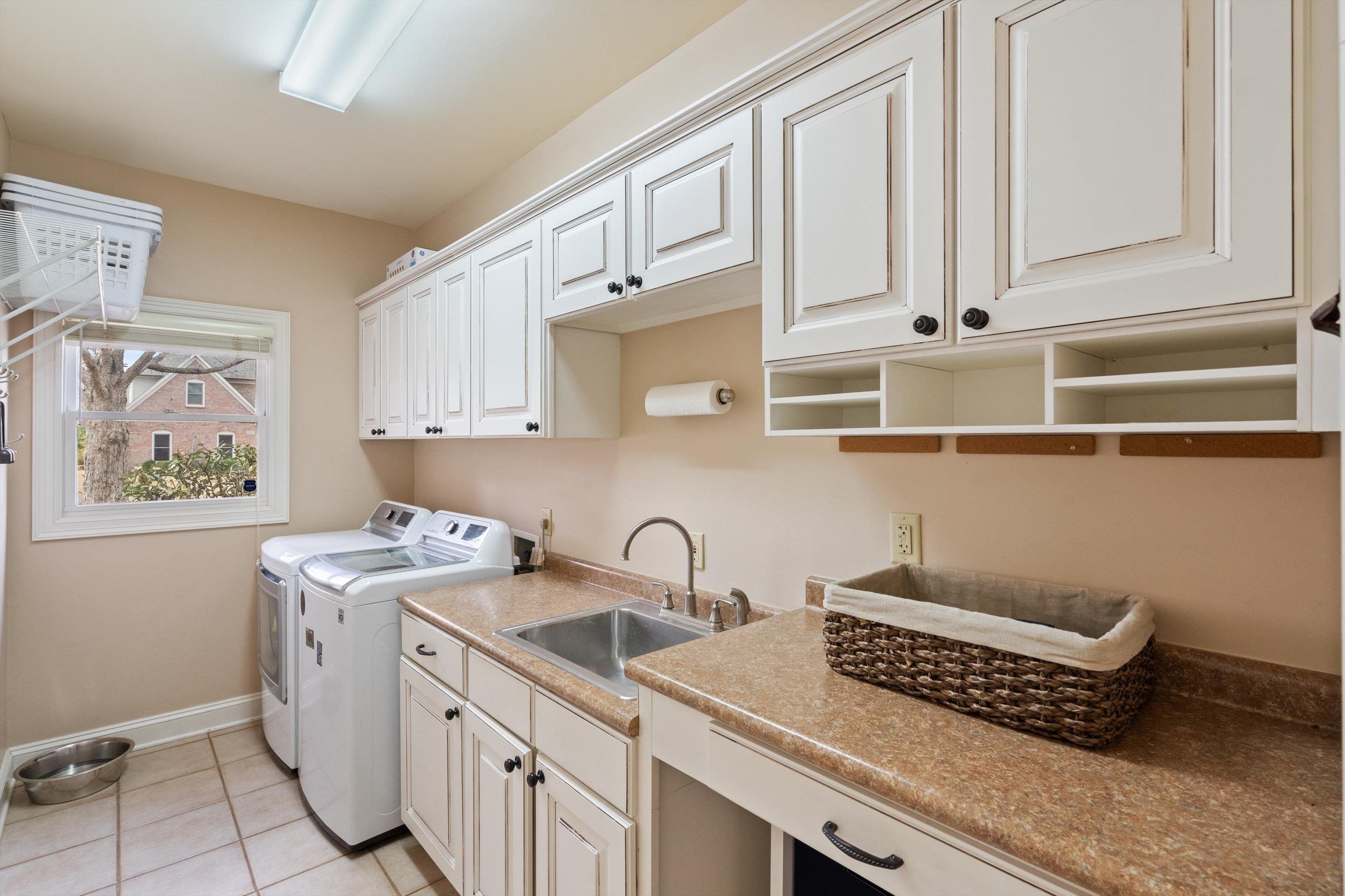 9335 Gresham Cove Germantown, TN 38139 - Photo 30 of 40 Clothes washing area with cabinets, sink, light tile patterned floors, and washer and clothes dryer
