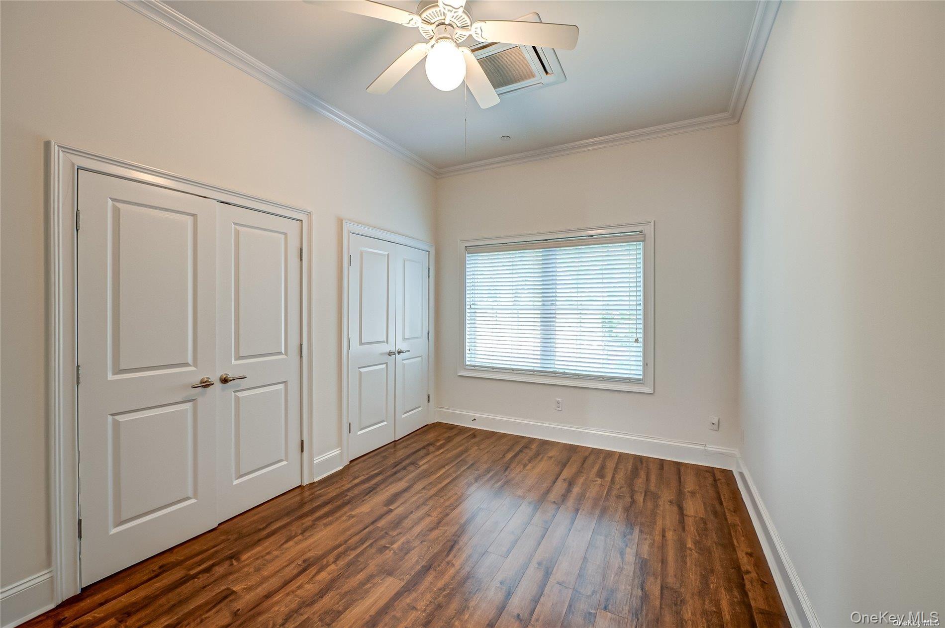 50 Stewart Avenue, Unit 3A Huntington, NY 11743 - Photo 6 of 13 an empty room with wooden floor cabinet and windows
