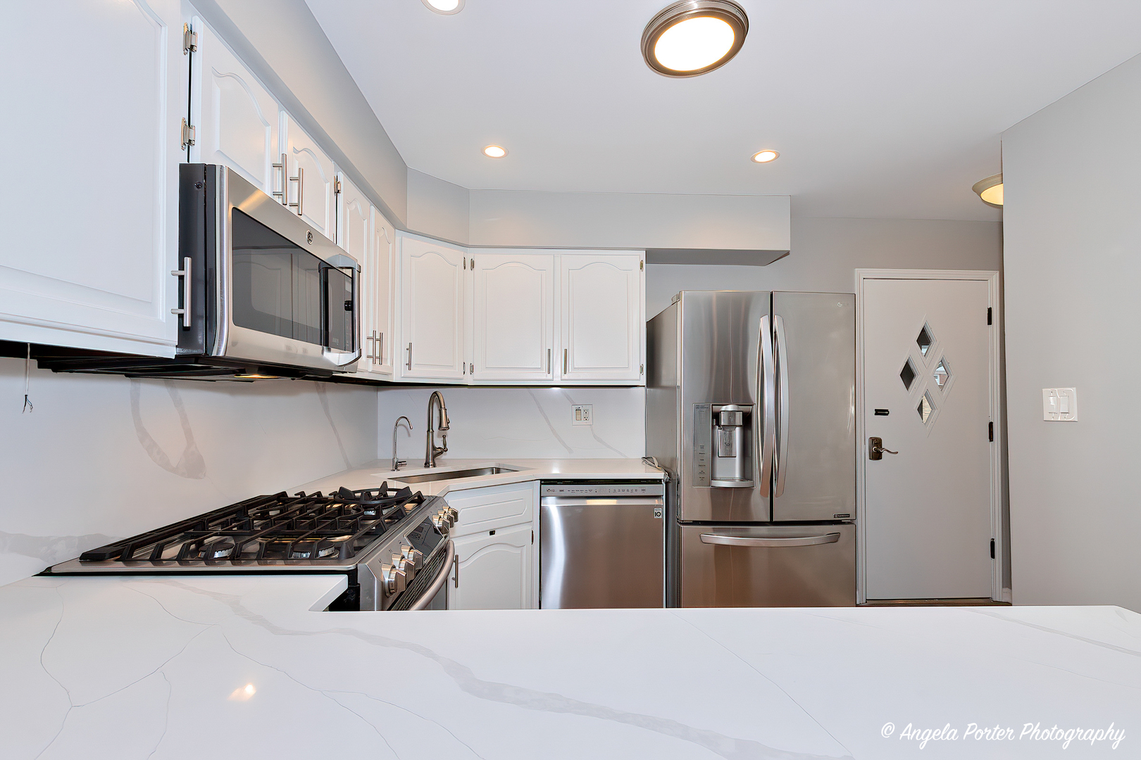 40 Pine Tree Row Lake Zurich, IL 60047 - Photo 5 of 31 a kitchen with stainless steel appliances granite countertop a sink a stove a refrigerator a microwave oven with white cabinets