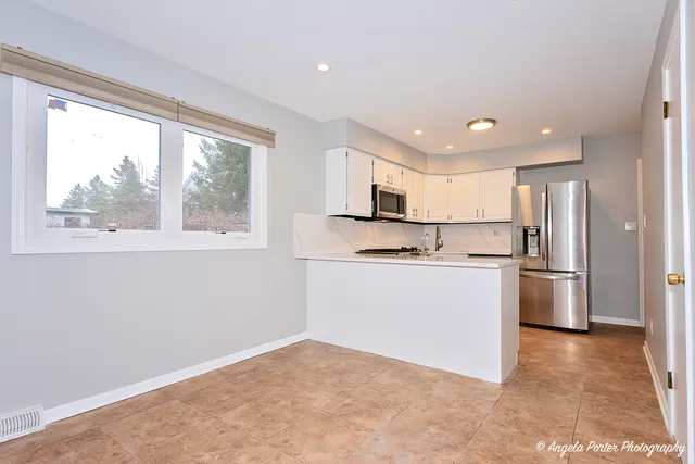 a kitchen with white cabinets and white appliances