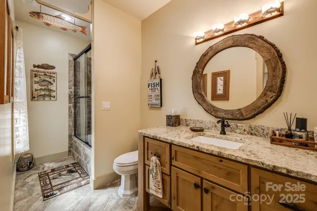 a bathroom with a granite countertop toilet a sink and a mirror