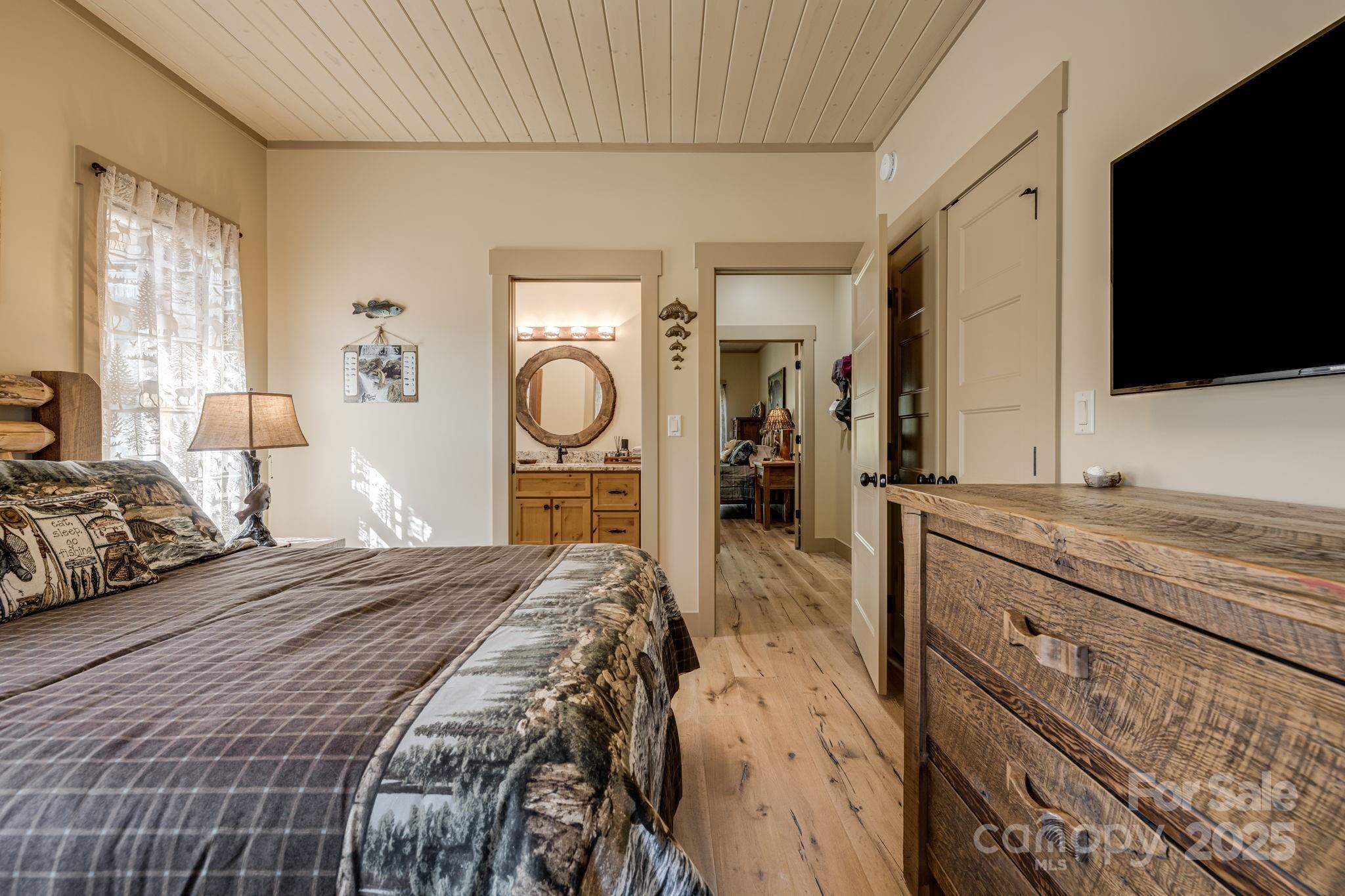 36 Chimney Stone Way Cullowhee, NC 28723 - Photo 20 of 47 a bedroom with a large bed and a flat tv screen on dresser