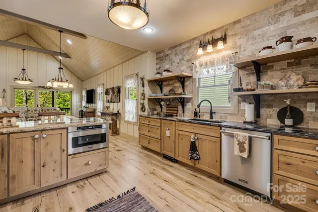 a kitchen with stainless steel appliances granite countertop a stove and white cabinets