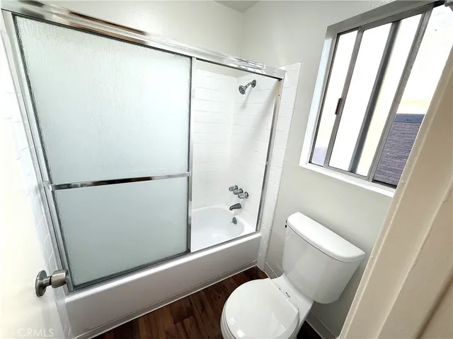 a white toilet sitting next to a shower