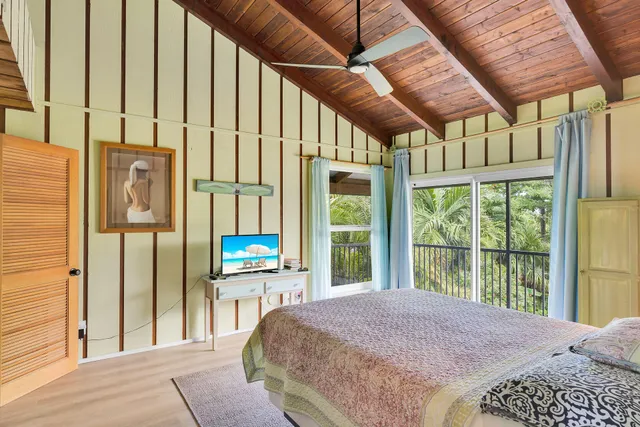 a bedroom with a bed and a large window with balcony view
