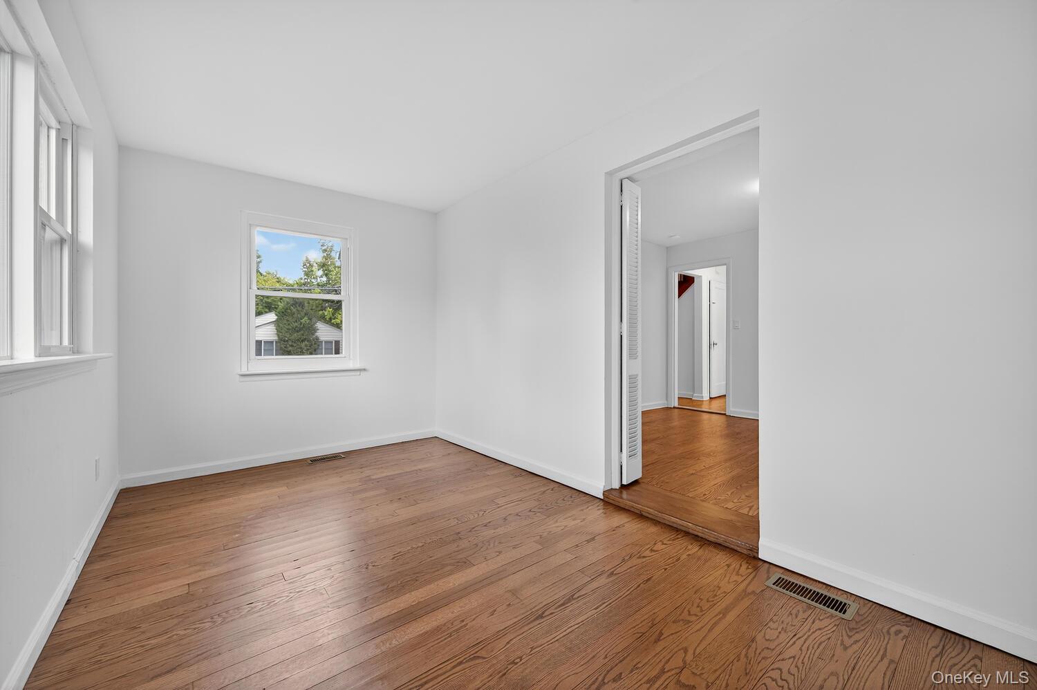 175 North Street Locust Valley, NY 11560 - Photo 11 of 40 an empty room with wooden floor and windows