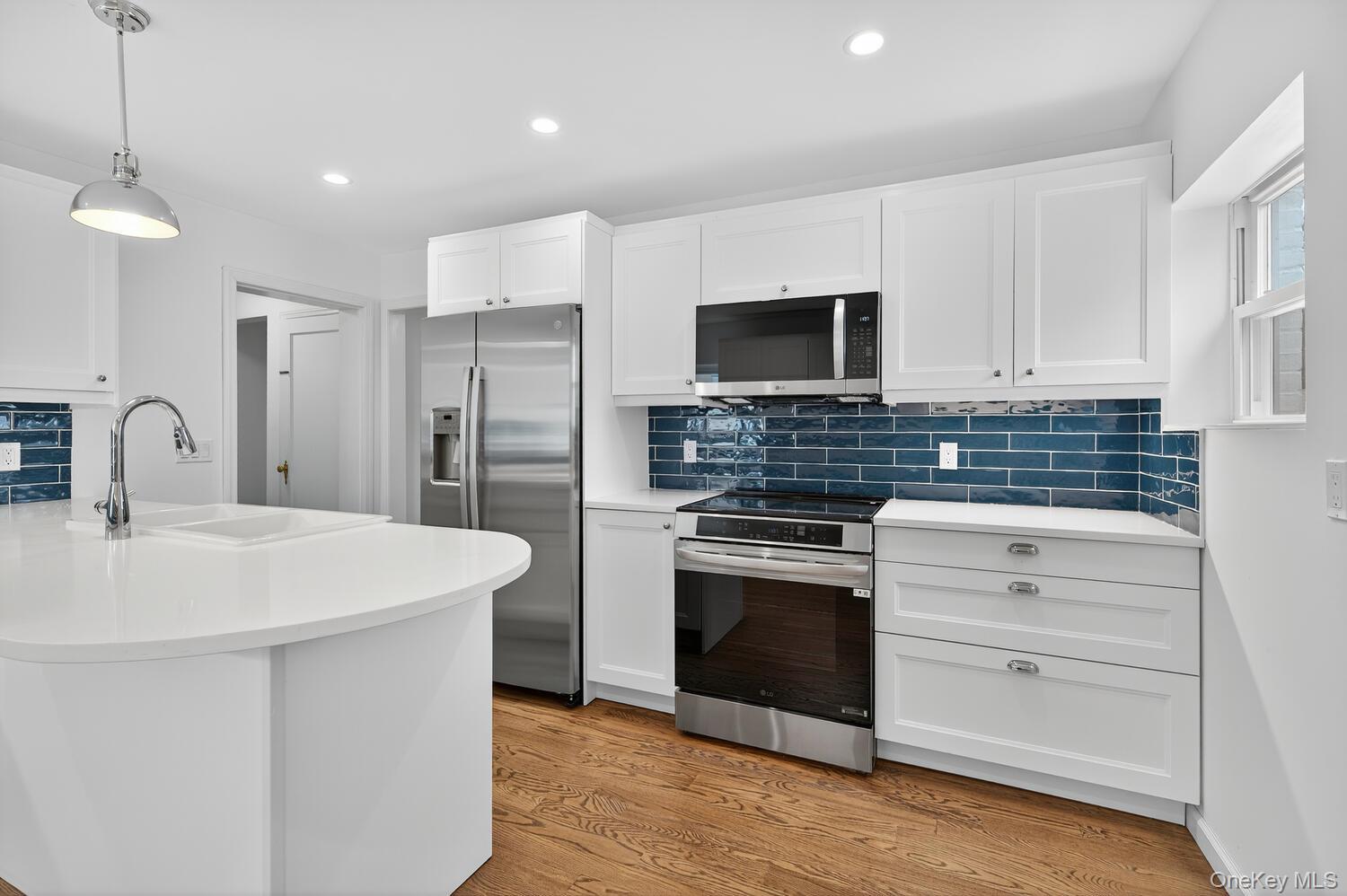 175 North Street Locust Valley, NY 11560 - Photo 14 of 40 a kitchen with white cabinets stainless steel appliances and a sink