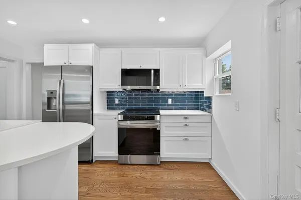 a kitchen with stainless steel appliances a stove microwave and refrigerator