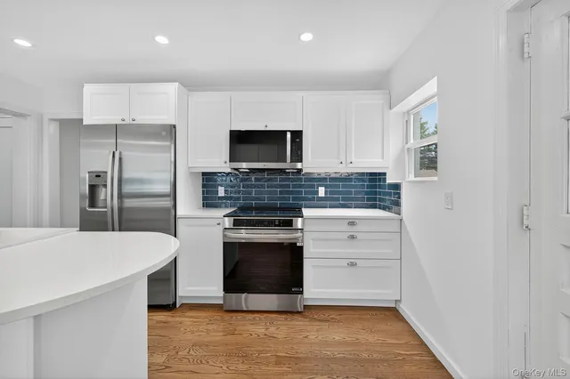 a kitchen with stainless steel appliances a stove microwave and refrigerator