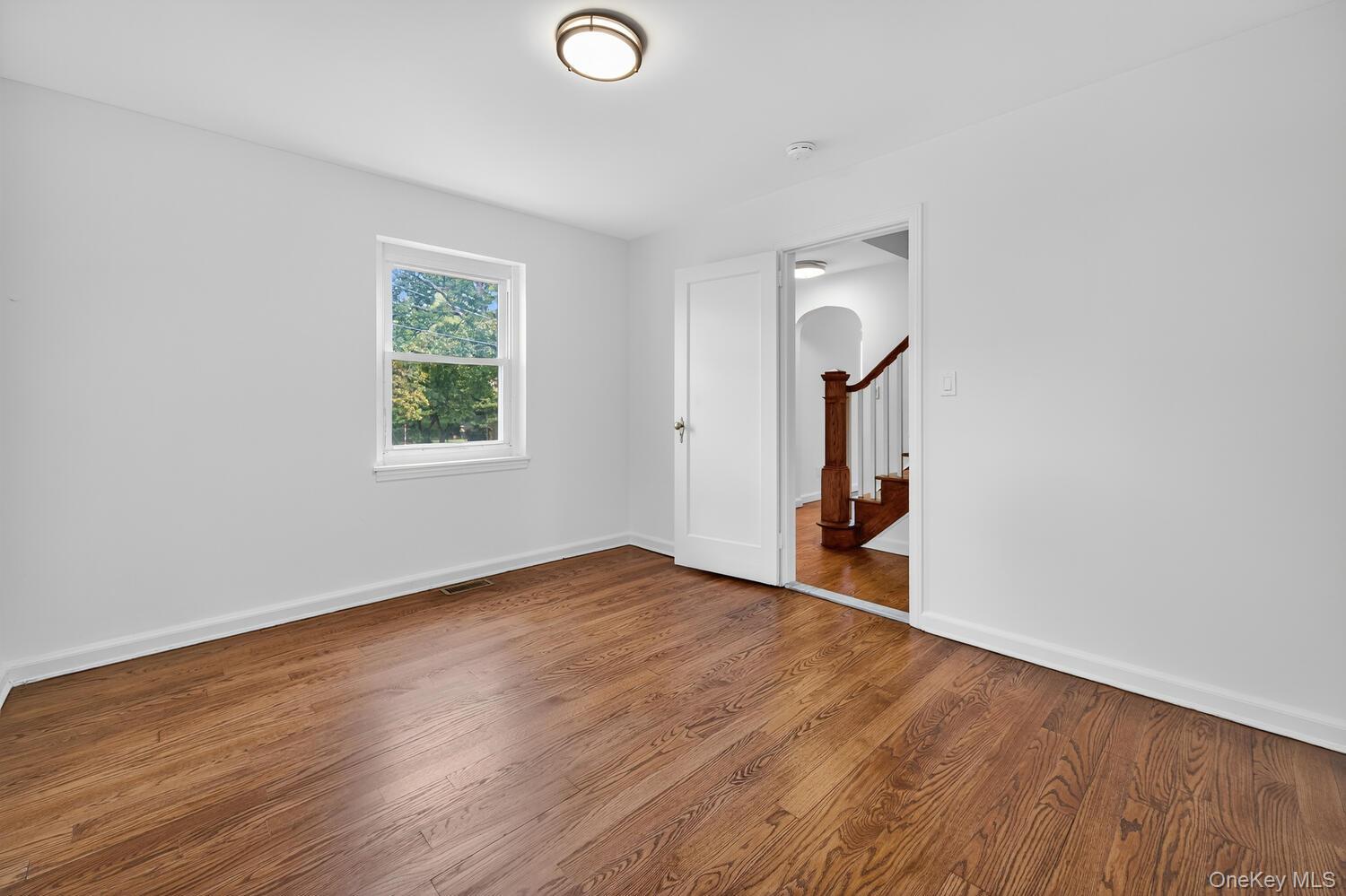 175 North Street Locust Valley, NY 11560 - Photo 20 of 40 an empty room with wooden floor and a window