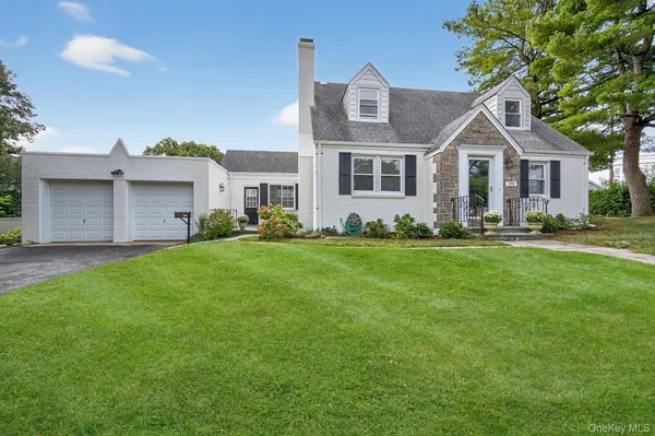 a front view of a house with a yard and trees