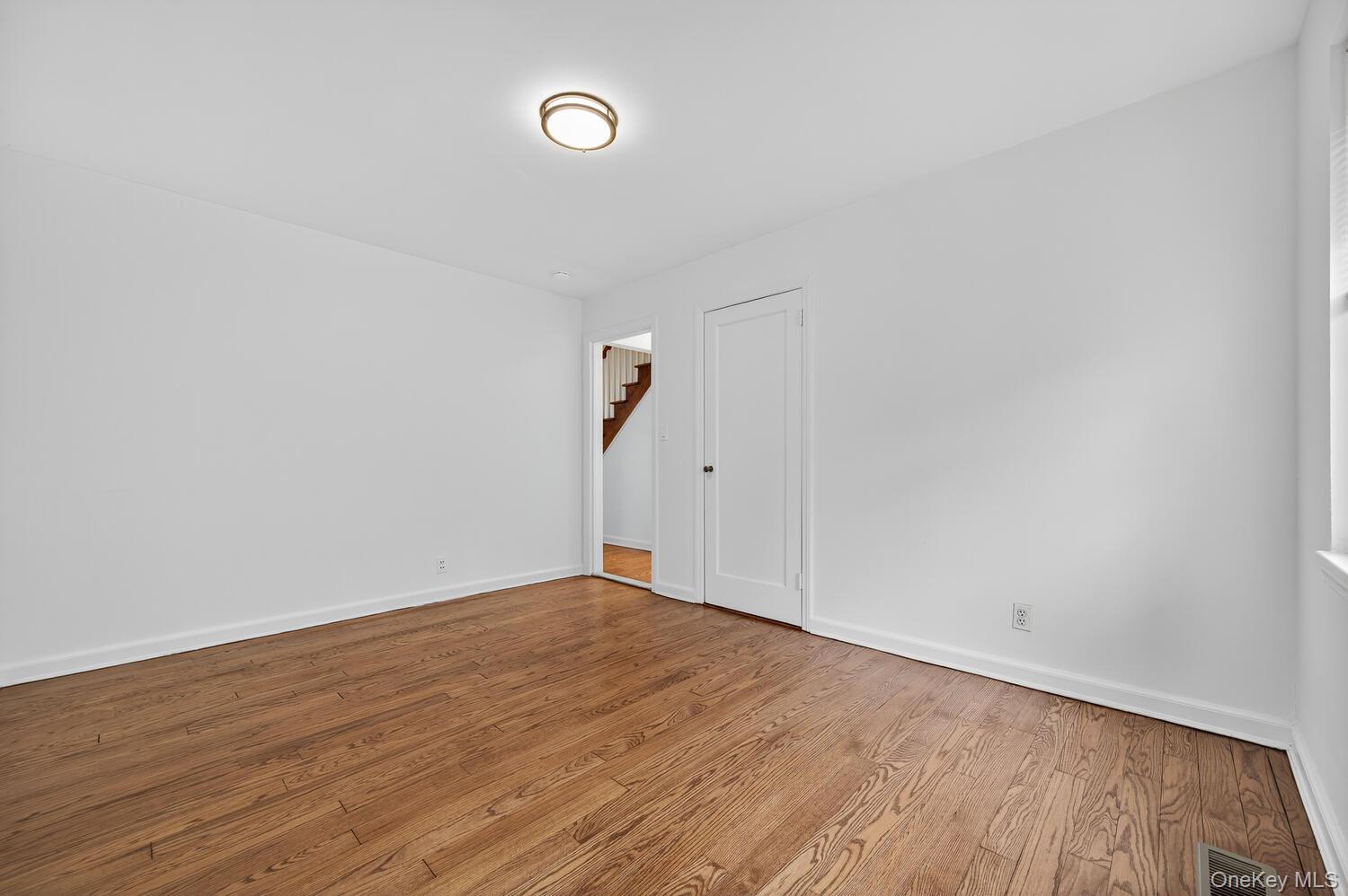 175 North Street Locust Valley, NY 11560 - Photo 22 of 40 an empty room with wooden floor and windows