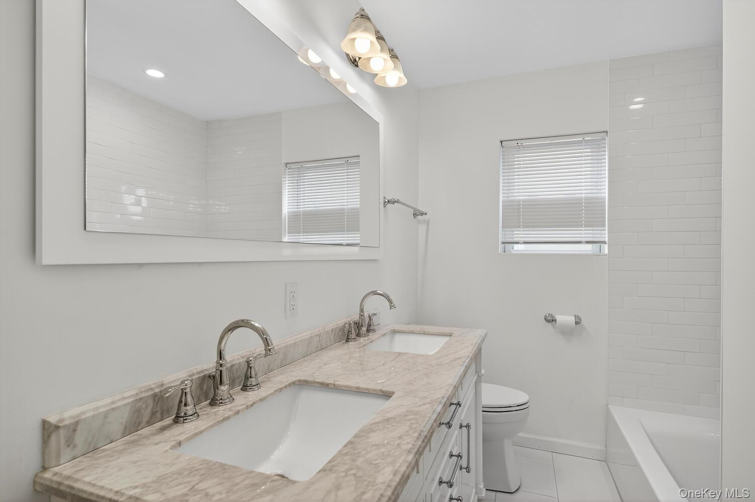 175 North Street Locust Valley, NY 11560 - Photo 23 of 40 a bathroom with a granite countertop sink a toilet and a mirror