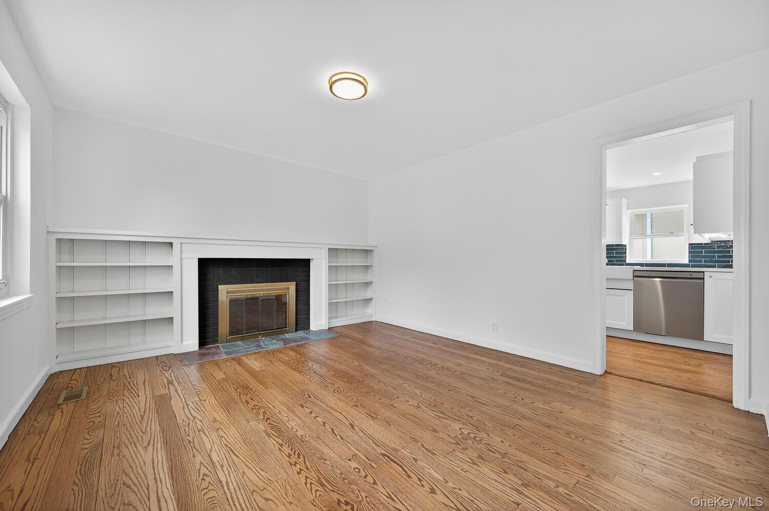 175 North Street Locust Valley, NY 11560 - Photo 5 of 40 a view of empty room with wooden floor and kitchen