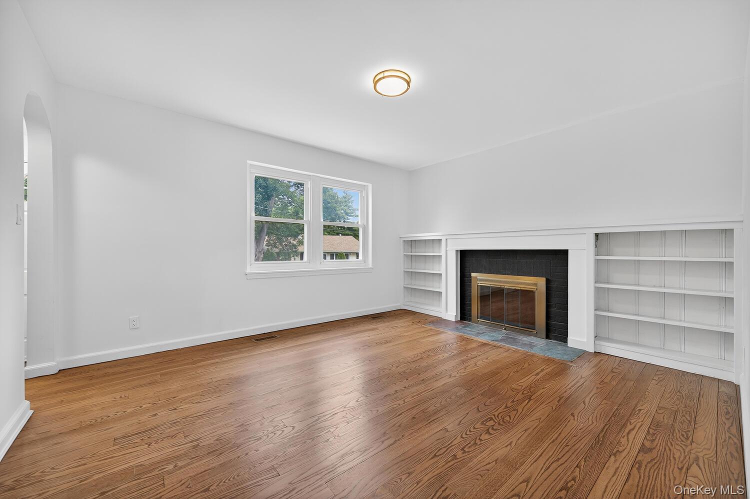 175 North Street Locust Valley, NY 11560 - Photo 6 of 40 an empty room with wooden floor fireplace and windows