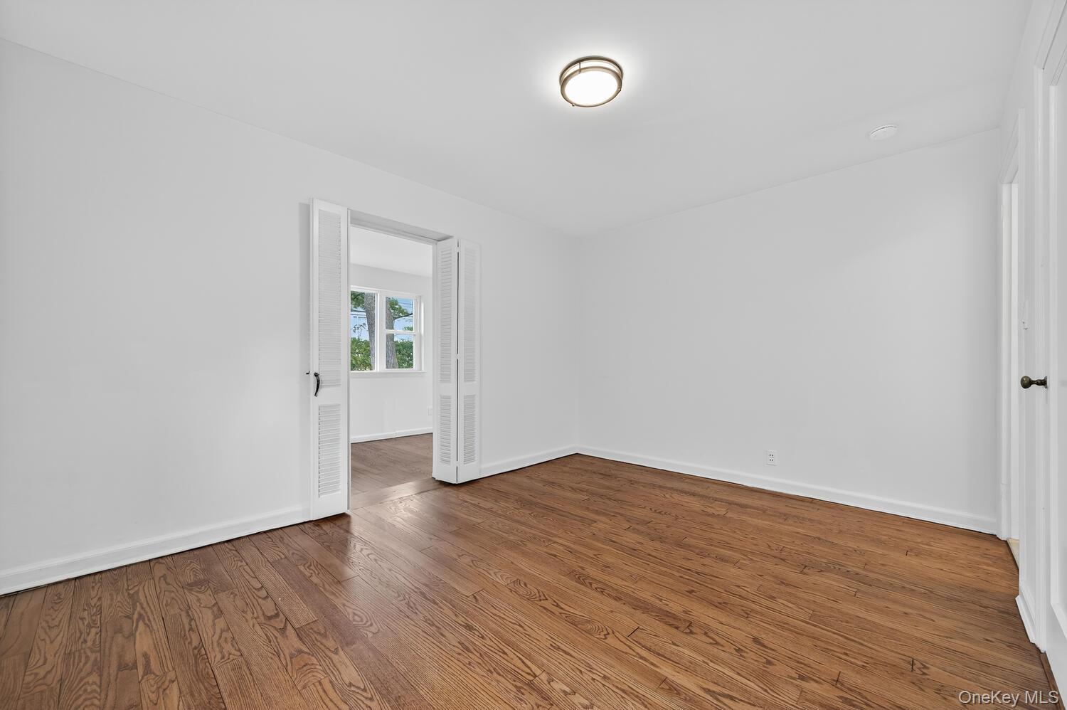 175 North Street Locust Valley, NY 11560 - Photo 9 of 40 an empty room with wooden floor and window