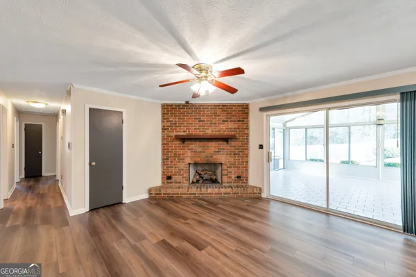 a view of an empty room with a fireplace and a window