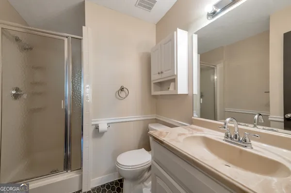a bathroom with a granite countertop sink toilet and shower
