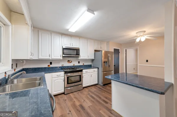 a kitchen with stainless steel appliances granite countertop a sink dishwasher stove top oven and refrigerator