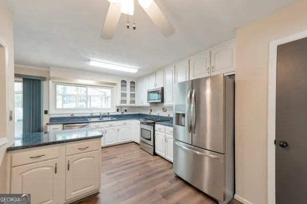 a kitchen with white cabinets and stainless steel appliances