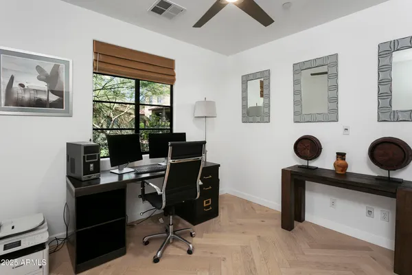 a view of a workspace with furniture and a window