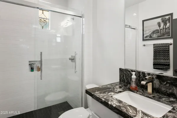 a bathroom with a granite countertop sink toilet and shower