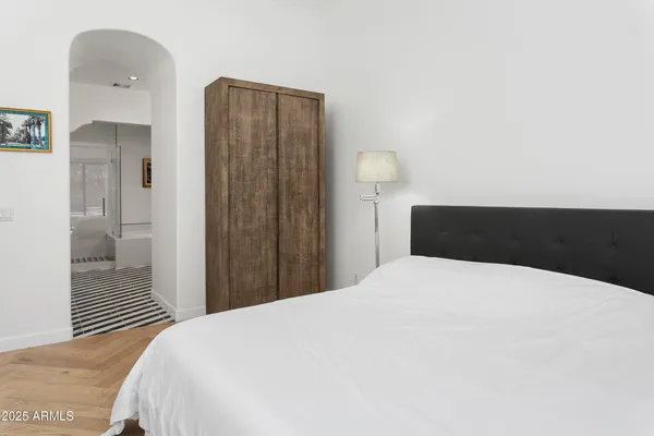 a bedroom with a bed and a mirror