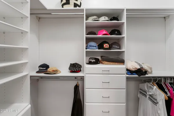 a view of walk in closet with clothes and shoes