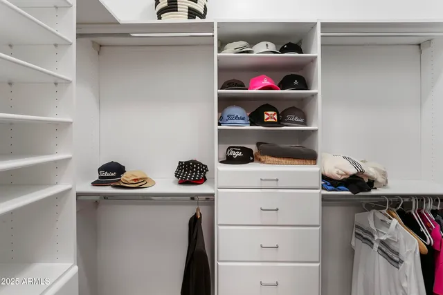 a view of walk in closet with clothes and shoes