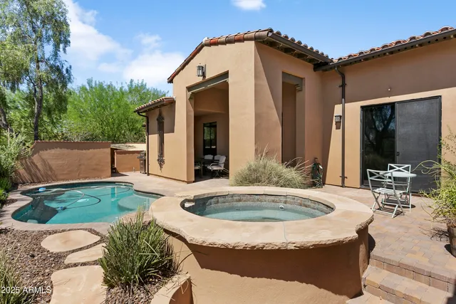 a view of a house with swimming pool and sitting area