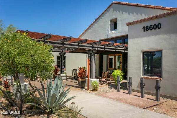 a view of a patio with table and chairs under an umbrella