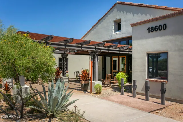 a view of a patio with table and chairs under an umbrella