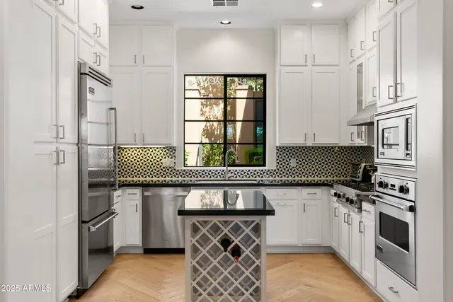 a kitchen with stainless steel appliances a stove a sink and a refrigerator