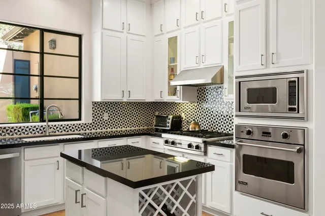 a kitchen with granite countertop a sink stove and cabinets