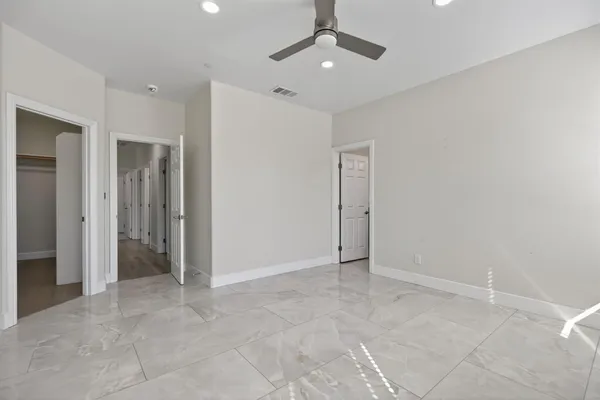 an empty room with fan and entrance