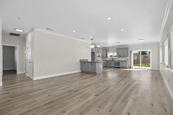 a view of empty room with wooden floor and window