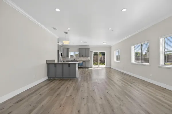 a large kitchen with a wooden floor and stainless steel appliances