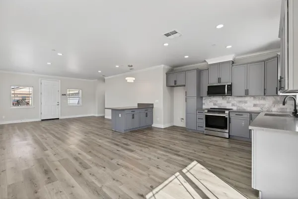 a large kitchen with kitchen island a sink stainless steel appliances and cabinets