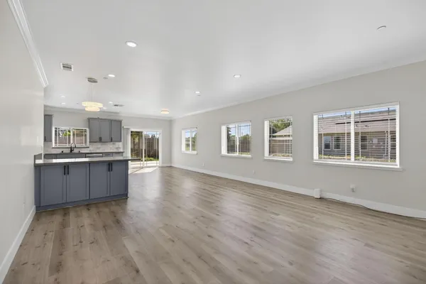 a large kitchen with a wooden floor and windows
