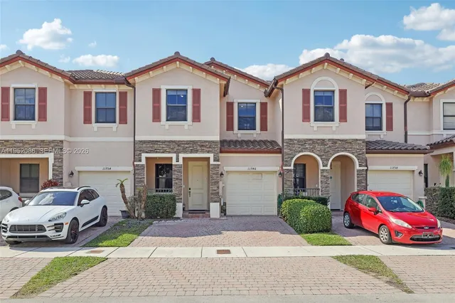 a front view of a house with cars parked