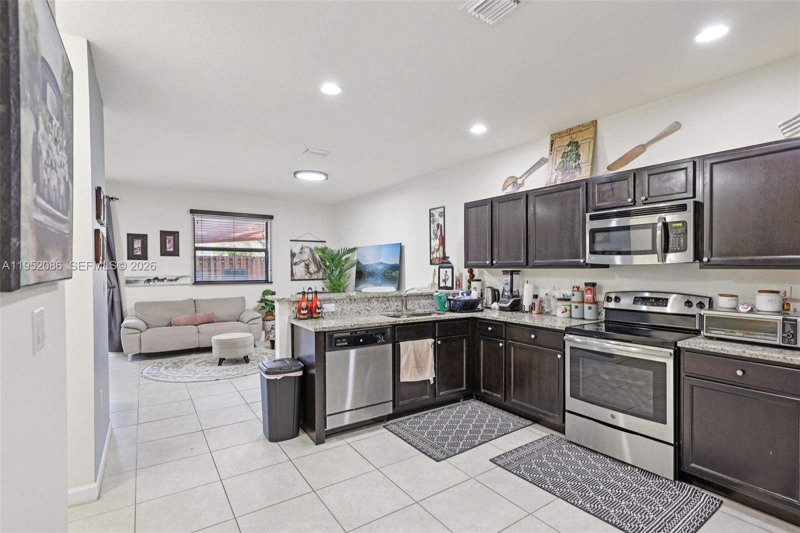 11746 Southwest 151 Avenue Miami, FL 33196 - Photo 12 of 37 a kitchen with stainless steel appliances granite countertop a stove top oven a sink dishwasher and a refrigerator