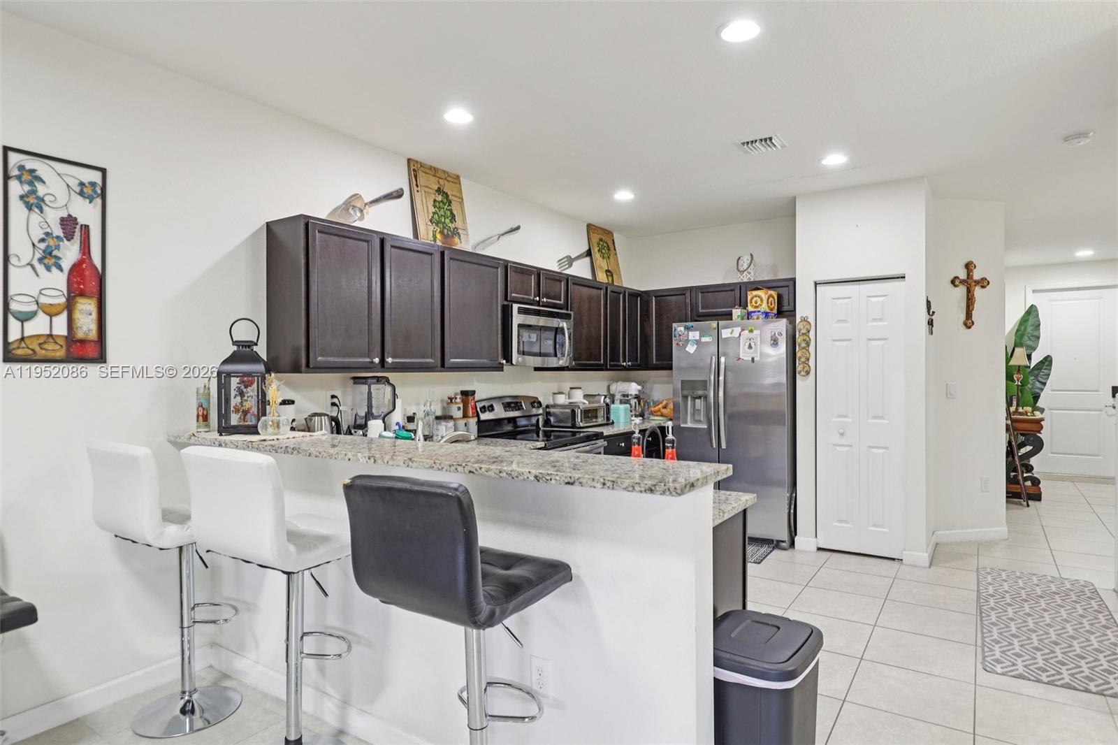 11746 Southwest 151 Avenue Miami, FL 33196 - Photo 13 of 37 a kitchen with refrigerator and chairs