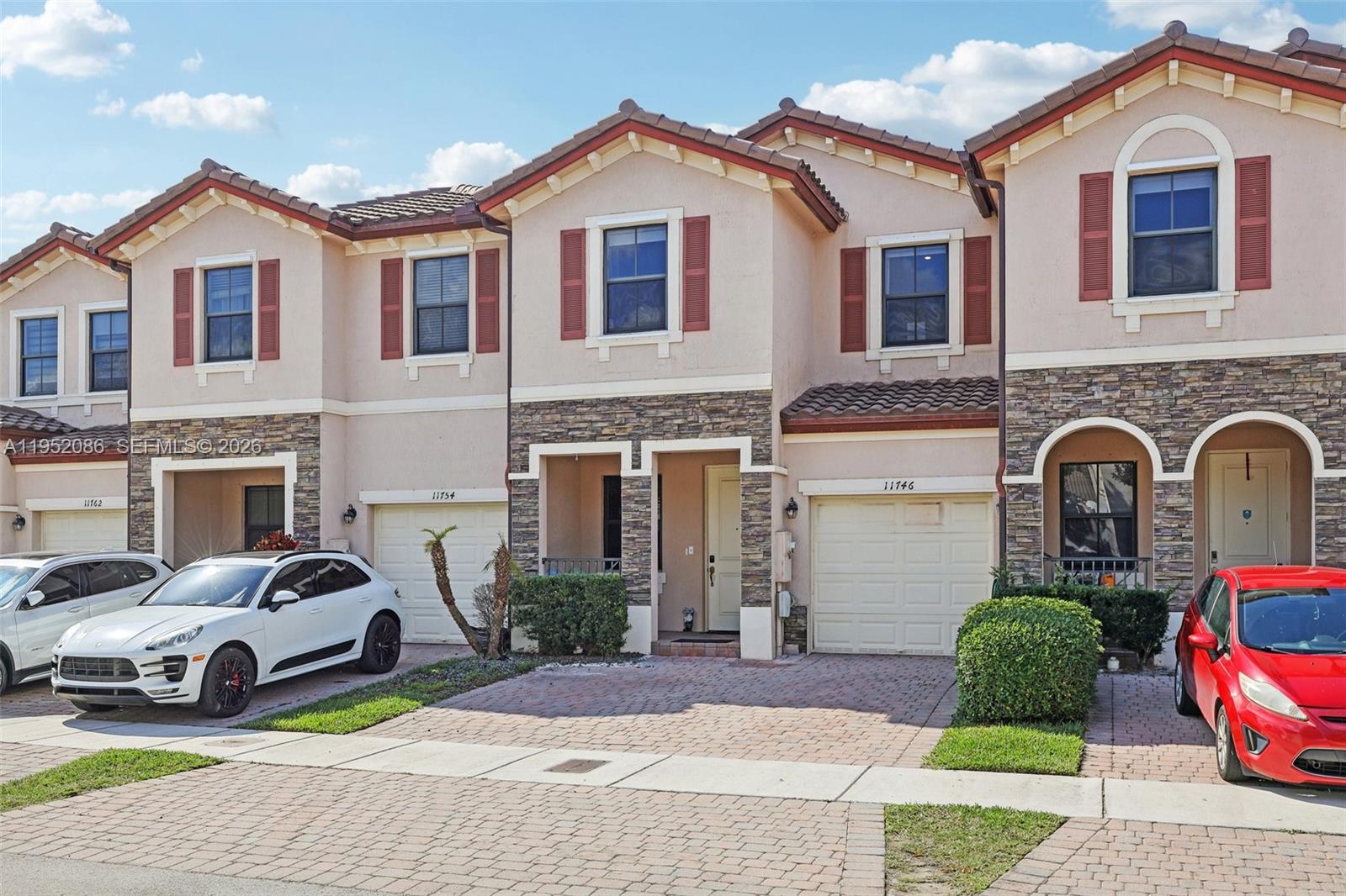 11746 Southwest 151 Avenue Miami, FL 33196 - Photo 2 of 37 a front view of a house with garage and parking